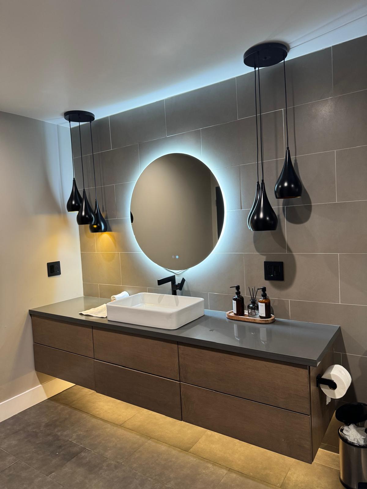 Modern bath with walnut floating vanity and backlit round mirror — O'ahu