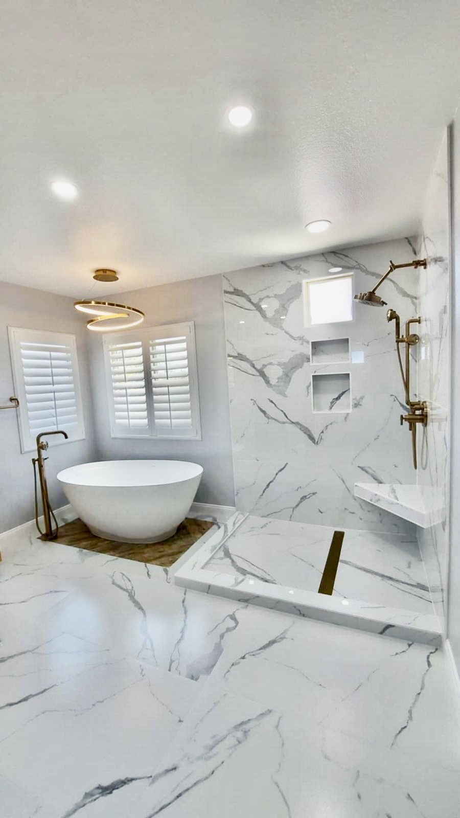 Marble master bath with freestanding tub and spiral LED chandelier — O'ahu