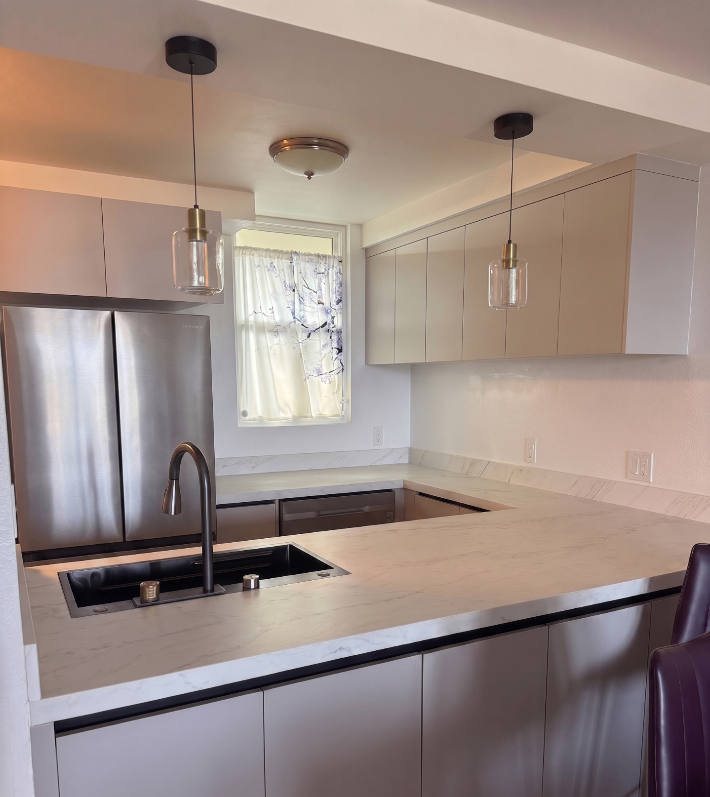 Taupe matte U-shaped kitchen with marble counters and brass pendants — Honolulu, O'ahu