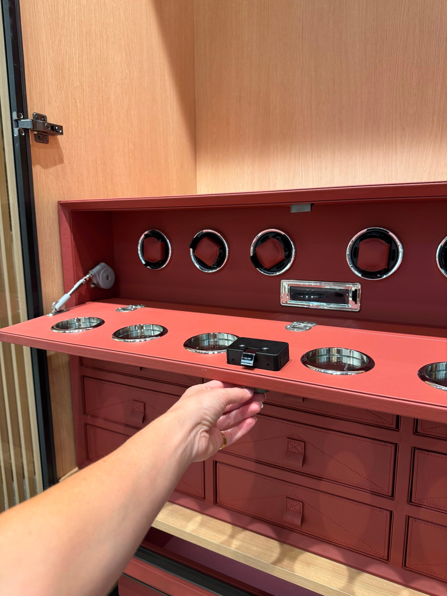 Coral leather-lined wardrobe insert with five watch winders, polished chrome jewelry cups and stitched leather drawers at Ward Design Center Kapolei