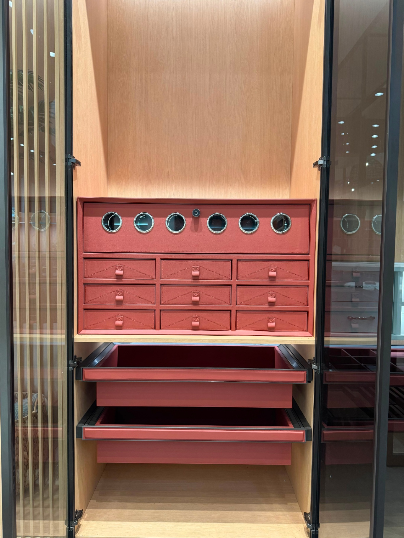 Luxury wardrobe interior with coral leather watch winder drawers, jewelry storage, and glass doors at Ward Design Center Kapolei