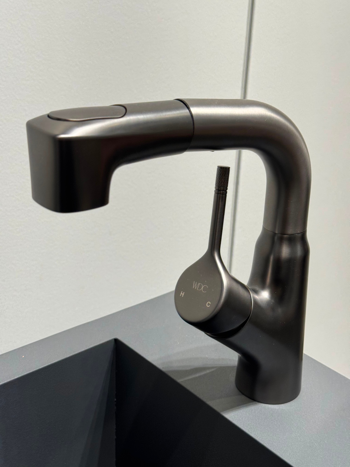 Gunmetal brushed kitchen faucet with pull-out sprayer, adjustable height spout and WDC-engraved handle on display at Ward Design Center showroom