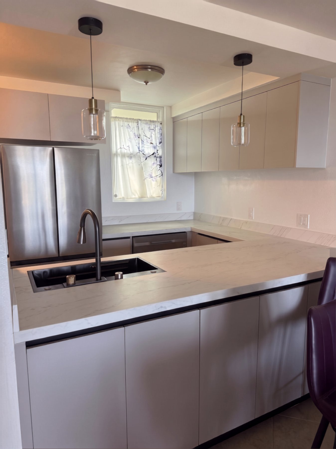 After: WDC stainless-steel kitchen remodel with marble-look counters and taupe cabinets