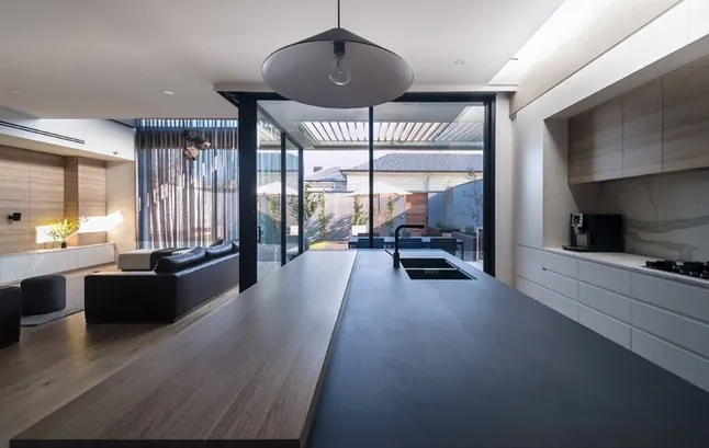 Modern custom kitchen with quartz waterfall island and integrated appliances, Oahu showroom