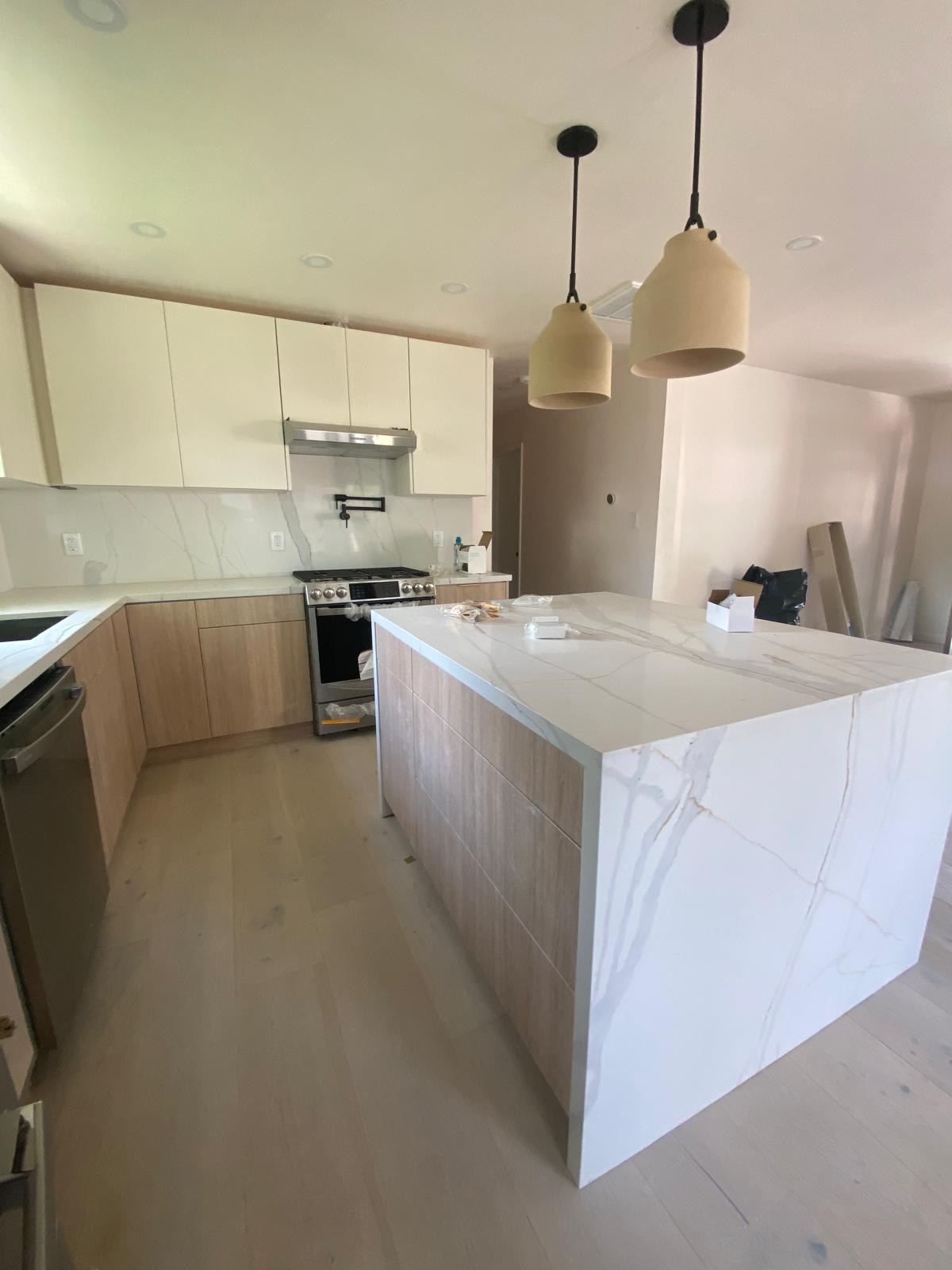 Light oak kitchen with Calacatta marble waterfall island — O'ahu