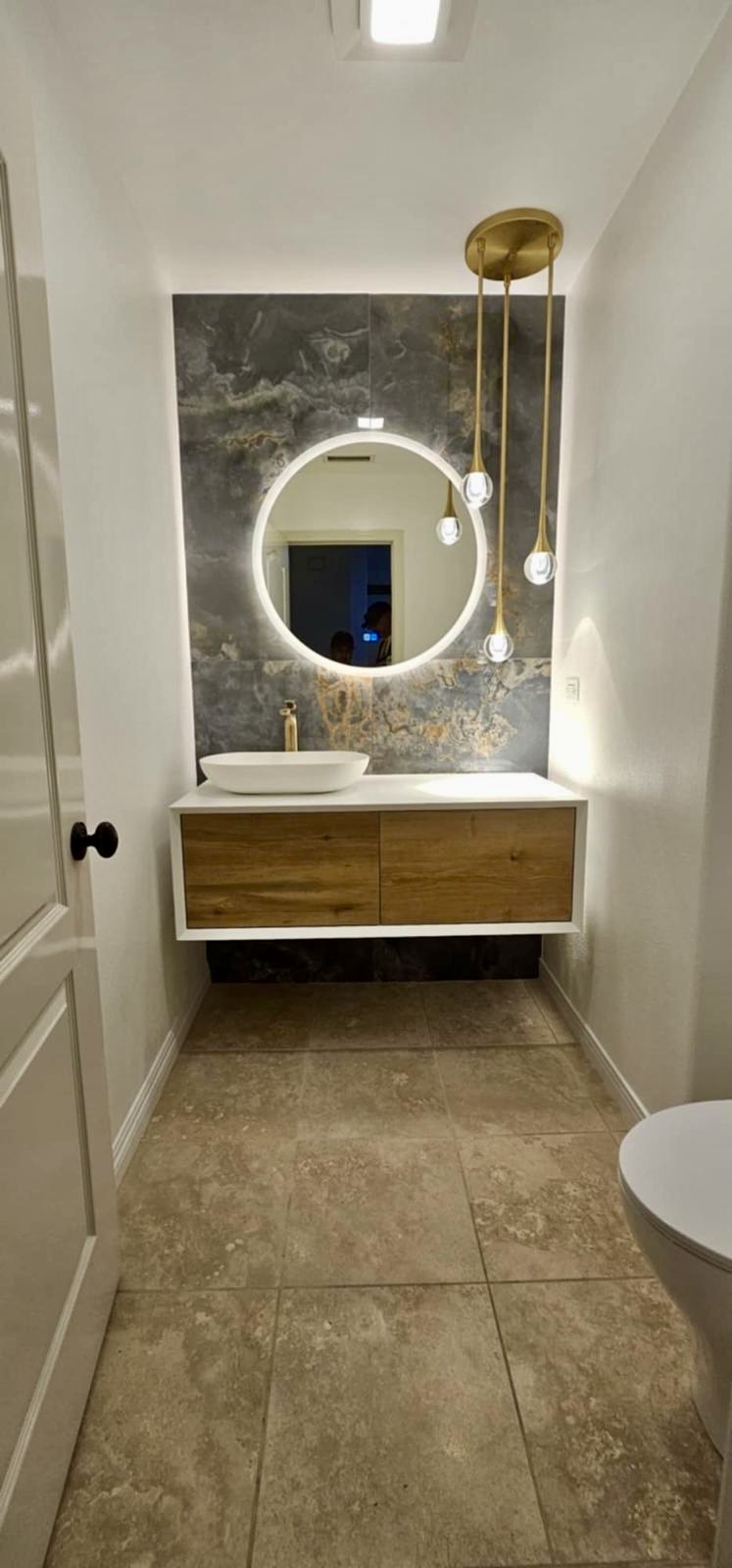 Powder room with floating oak vanity and brass pendant cluster — O'ahu