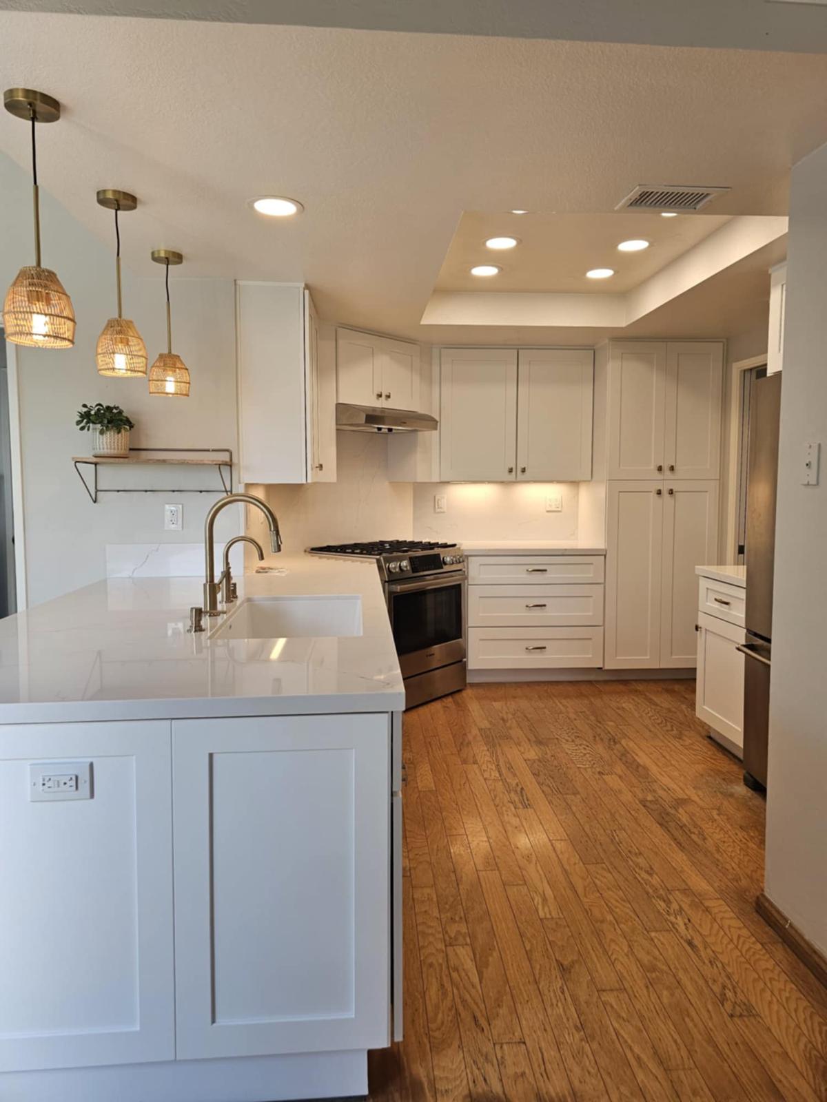 White shaker kitchen with rattan brass pendants, quartz island and oak floors — Mililani, O'ahu