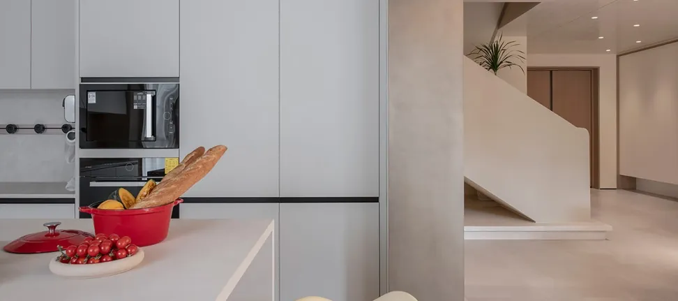 Modern custom kitchen with quartz waterfall island and integrated appliances, Oahu showroom